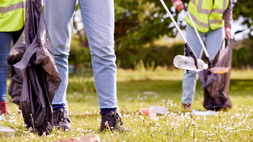 People using garbage pickers and garbage bags to pick up litter