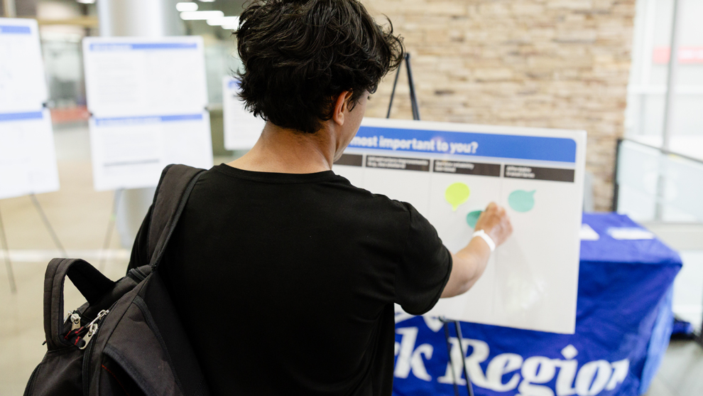 women adding sticky notes onto a board