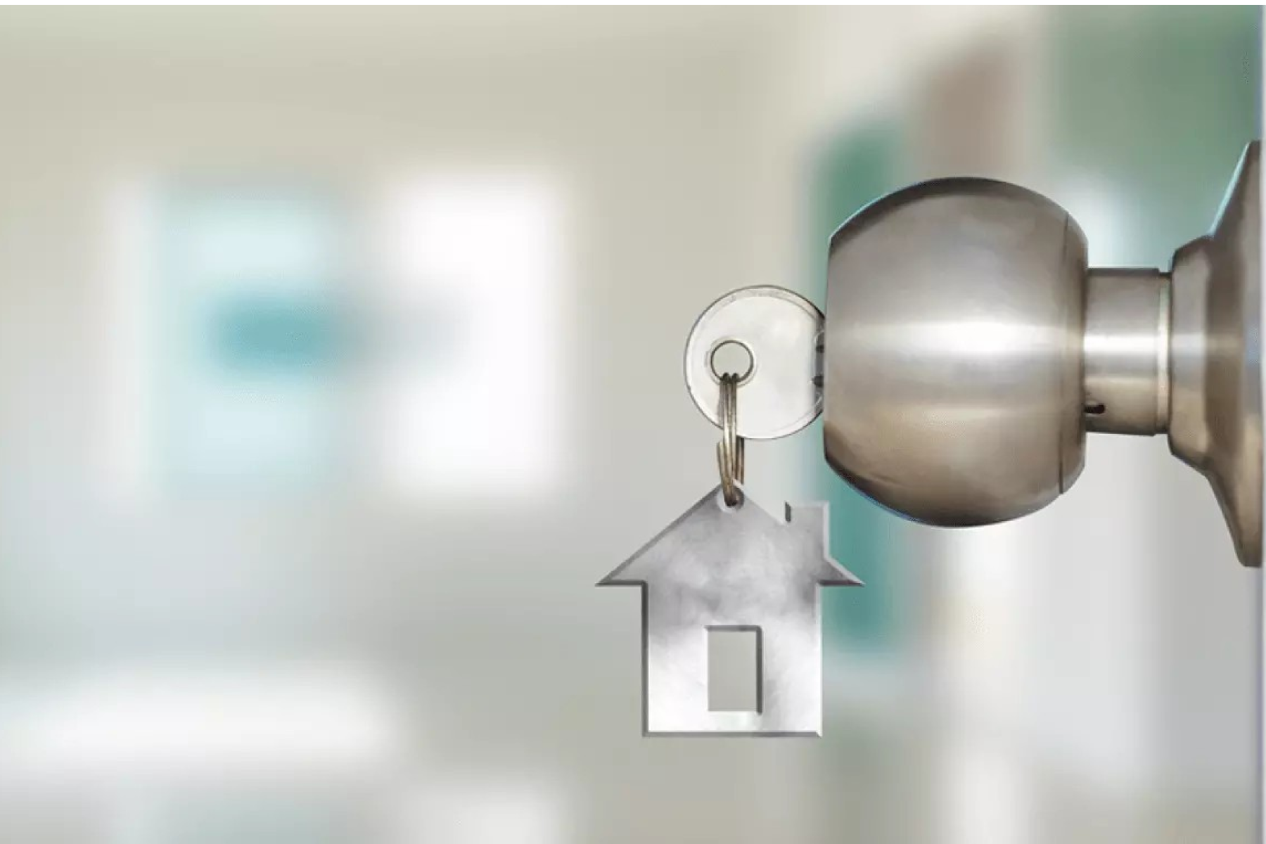 image of a door handle with a key in the lock and a keychain that looks like a home