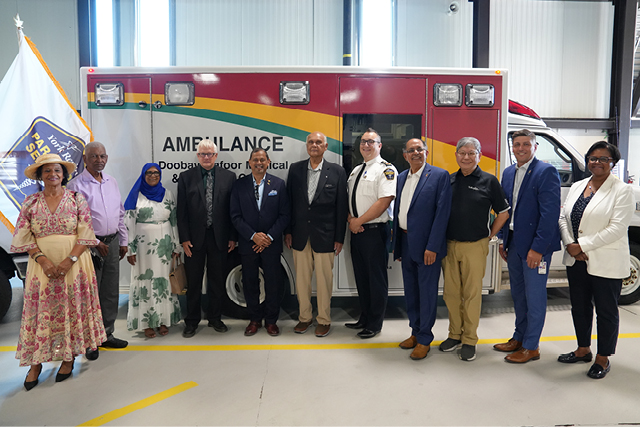 A group of people standing in front of the decommissioned ambulance