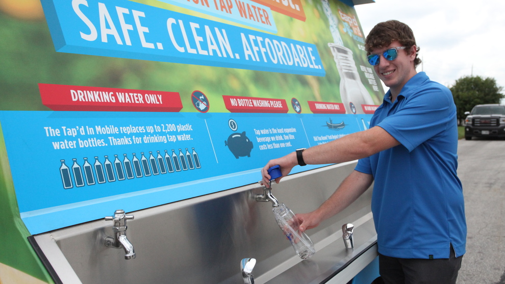Person filling water from the mobile drinking water trailer