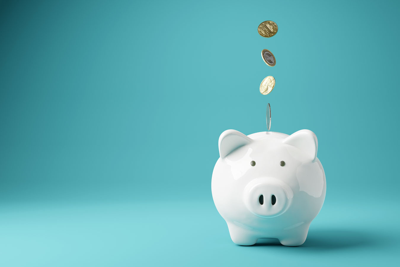 Coins dropping in piggy bank