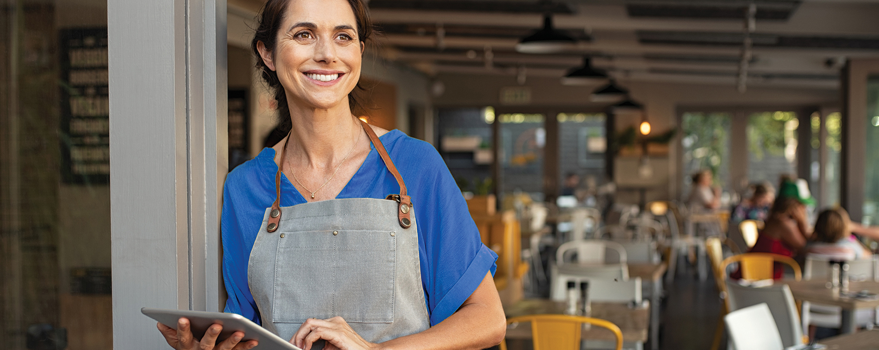 ICI_WebBanner_2025 Business woman with a tablet in a restaurant