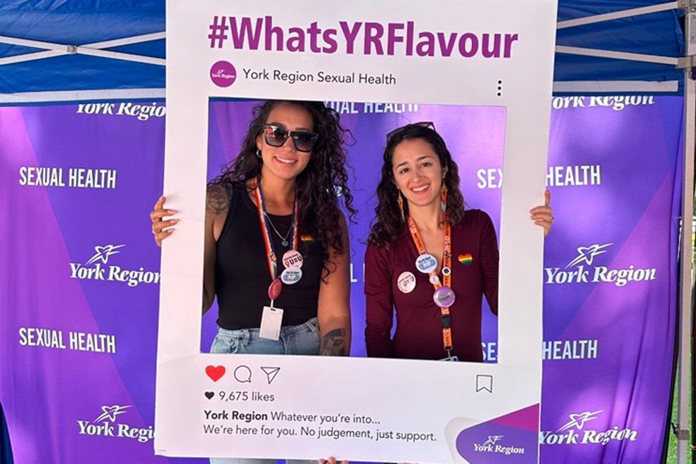 two visitors using a public health outreach prop to take a selfie