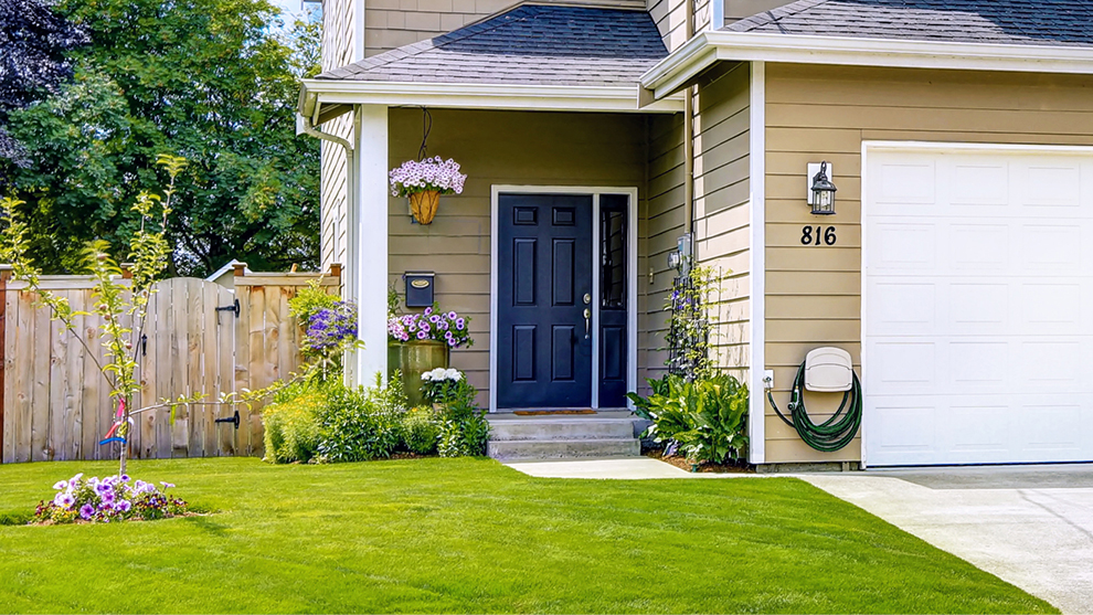 the front lawn and driveway of a house in the suburbs