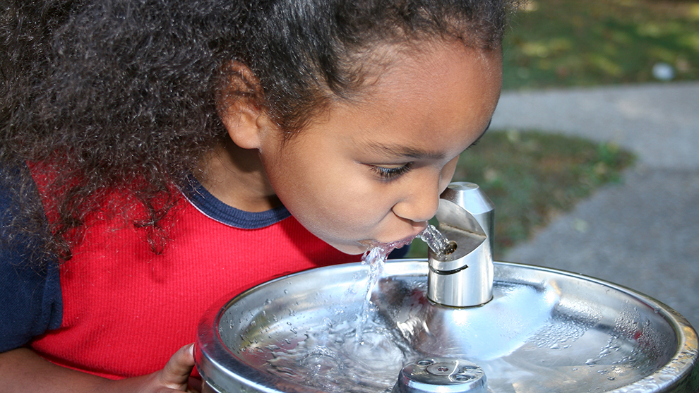 Child drinking water from a fountain