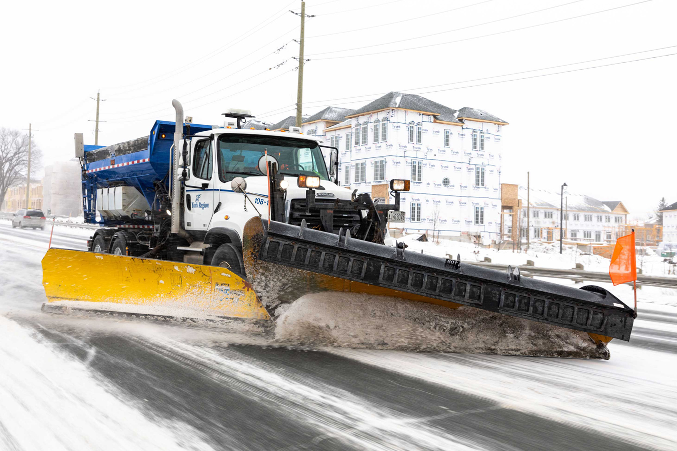 snow plow clearing snow on a regional road