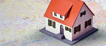 Photo of a small house model ontop of a map