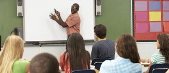 Teacher at the front of class instructing students